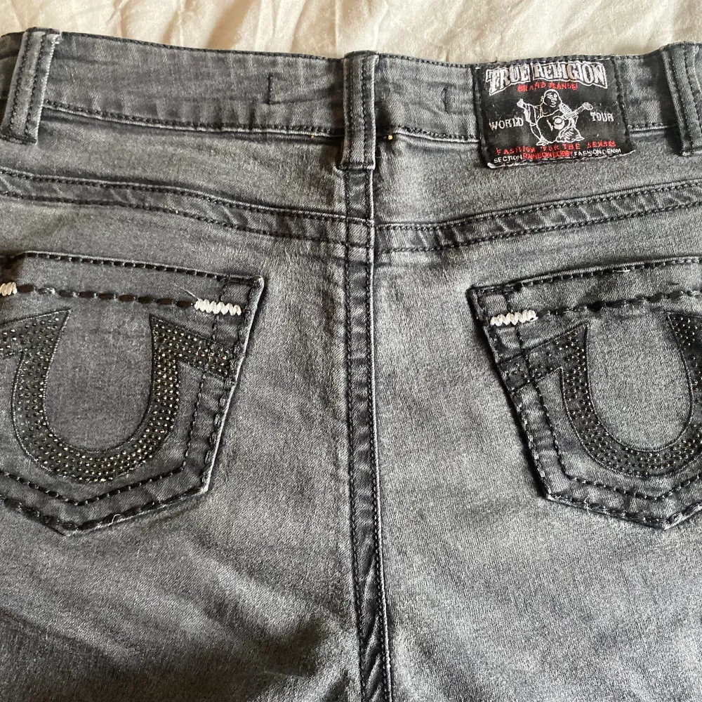 Säljer mina svarta true religion jeans med glitter aktiga detaljer på fickorna. Byxorna är i storlek 33 men jag skulle säga att dom sitter bäst på någon med storlek XS då dom är korta för att vara storlek 33. Jeans & Byxor.
