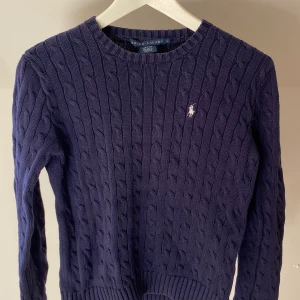 Ralph Lauren sweater stickad tröja - Mörkblå stickad tröja från Ralph Lauren storlek L men sitter oversize på en storlek XS/S/M. Använd sparsamt men i väldigt bra skick och god kvalitet. Nypris ca 1500 kr