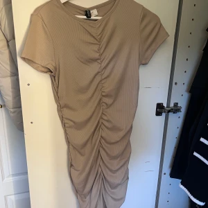 Beige T-shirtklänning - En Beige T-shirtklänning från H&M i storlek L, aldrig använd, lappar finns kvar