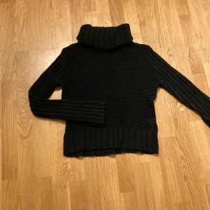 Svart polotröja - En svart stickad polotröja, med långa armar.