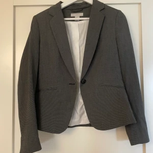 Kavaj - Skit snygg grå kavaj med litte vaddering vid axlarna. Använd ca 1 gång tidigare. Den är i storlek 38 men passar även för 36&34