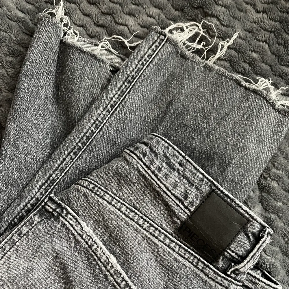 Ett par fina mörkgråa jeans (straight mom jeans) med slits på ena sidan. Knappt använda och är i bra skick. Jeans & Byxor.