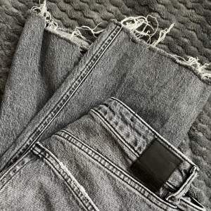 Ett par fina mörkgråa jeans (straight mom jeans) med slits på ena sidan. Knappt använda och är i bra skick