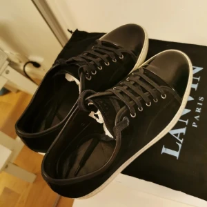 Lanvin dbb1 - Tja! Säljer mina glansiga lanvin dbb1 i svart färg då jag tröttnat på dem. Skorna kommer med låda och dustbag och är givetvis äkta. Skorna är i storlek uk 9 och passar eu 43-44. Skulle säga att skicket är 8/10 utan märkbara skavanker. Bud eller bin (2300)