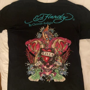 Vintage Ed Hardy T-shirt - Säljer en vintage Ed Hardy T-shirt i svart färg med ett multifärgat tryck. Baksidan har även märket på :). Storleken är XL men passar mindre storlekar som perfekt oversized.