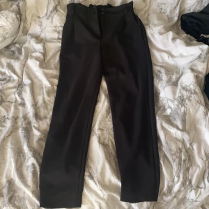 Kostymbyxor  - Hög midjade kostymbyxor med fickor där bak