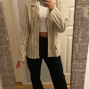 Randig kavaj, second hand  - En kavaj som är köpt på second hand butik men tyvärr inte kommit till användning. Passar som storlek XS/S/M beroende på önskad passform. Passform S på mig. Färgen är benvit/brun och med lite skimmer. Pris: 80kr exklusive frakt.