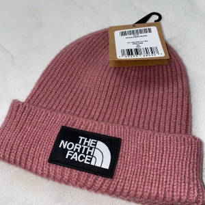 The North Face - Helt ny mössa från The North Face som jag fick med vid köp av jacka 2 år sedan. Rosa one size. Nypris är 340kr, säljer för 140+frakt