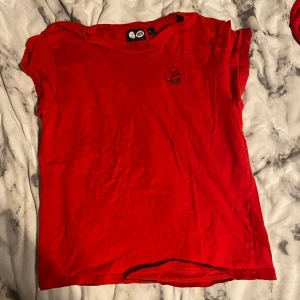 Röd t-shirt  - En röd t-shirt med ett litet döskalle tryck på vänstra bröstet 