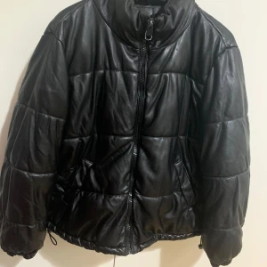 Svart puffer jacka i storlek 42 - Svart puffer jacka i storlek 42. Ny skick. Köparen står för frakt.