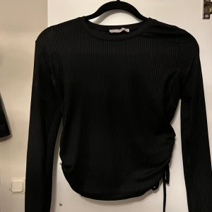 Svart topp - Svart topp i storlek S med snöring på båda sidorna så man kan välja hur högt man vill ha tröjan, använt endast 1 gång.💞