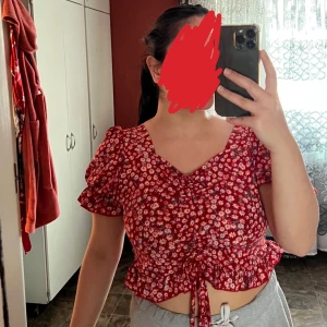 Röd blommig topp - Röd blommig topp från shein i storlek Xl men är ganska liten drf så stor storlek köptes den i är mera som S/M/L,går även att ta ner armarna och göra till off shoulder, aldrig användt.💞