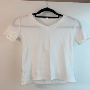 Ribbstickad - Ribbstickad t-shirt. Den är strl L, men den är extremt tajt iallafall på mig, den skulle nog passa en small/liten medium.