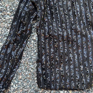 Glittrig långärmad tröja  - Svart topp med axelvaddar, och Paljetter i randigt mönster. BikBok stl S.