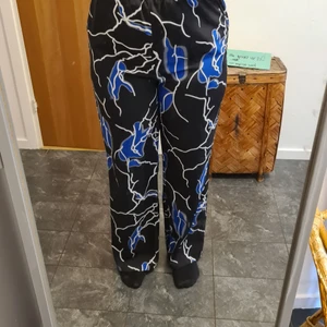 Svarta byxor med blå blixt storlek L - Ett pår byxor som jag aldrig har använt så dom är som nya. Jag är 163 om ni vill gämföra byxlengden 