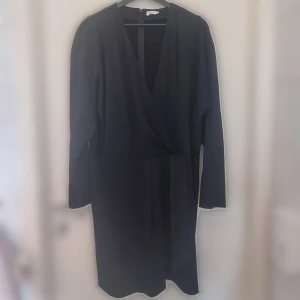 Filippa K festklänning storlek XL - Köpt vintage, men aldrig använt den själv. Jättefint skick med lite batwing i ärmen. På framsidan är det omlott detalj. 