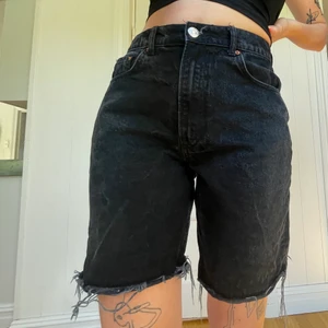 Svarta jeansshorts  - Lite längre svarta jeansshorts som jag helt enkelt inte använder länge! Sitter tajt runt men löst runt benen o slutar ovanför knäna! 