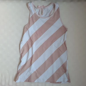 Rosa randigt linne i st XS - Rosa och vit randigt linne. Står storlek 122/128 men jag som är 15 år kan ha den och uppskattningsvis skulle jag säga att den sitter som en XS. Den är inte så strechig, men väldigt gullig.