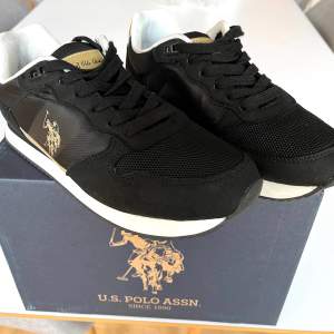 Sneakers, US Polo Assn säljes. Svarta med guld detaljer. Använda ett fåtal gånger, så väldigt fina. Psssar dessvärre inte min fot. 