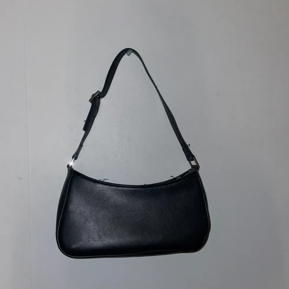 Säljer denna svarta baguettväska från Monki då den ej används längre. Använd en del men fortfarande i fint skick! 80kr plus 39kr frakt . Väskor.