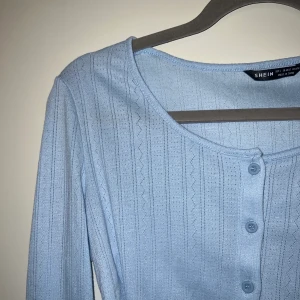 Tunn blå kofta - Säljer en jättesöt kofta/topp då den aldrig kommer till användning 💕 den har aldrig använts, endast provad, så är i bra skick! Den är i storlek L, men jag skulle mer säga att det är en M/S och den passar förmodligen xs bra också. Skriv för mer info💕💕💕