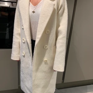 Vit HM kappa - Fin vit lite lurvig i materialet, varm och skön! Storlek XS/34 men skulle säga att den passar någon som är S/36/38 också