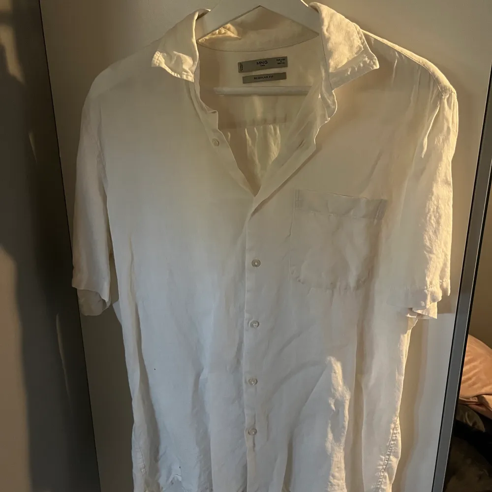En härlig linneskjorta från Mango i vit krämig färg som är perfekt till sommaren. Ganska använd men fortfarande i gott skick.. Skjortor.