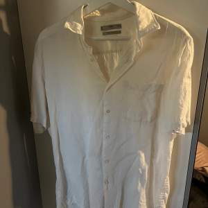 En härlig linneskjorta från Mango i vit krämig färg som är perfekt till sommaren. Ganska använd men fortfarande i gott skick.