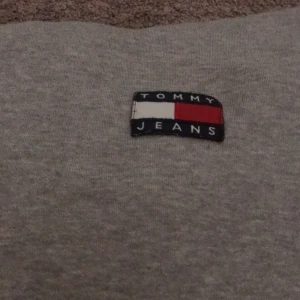 Hoddie Tommy jeans  - En hoddie från Tommy jeans. Näst intill oanvänd. Snörerna saknas men annars inget tecken på slitage. Storlek xs. Säljer den för 150kr+frakt. Priset kan absolut diskuteras vid snabb affär🥰🥰