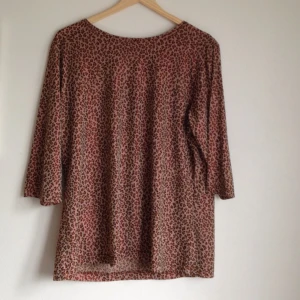 Oversized leopardmönstrad t-shirt med skimrande rött glitter - Oversized leopardmönstrad t-shirt med skimrande rött glitter
