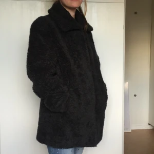  - Kappa i fejkfårpäls.