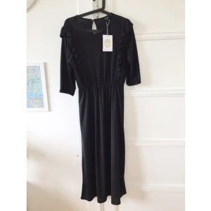  - Långklänning med prislapp kvar. Alltså aldrig använd. Trekvartsärmar och volanger fram och bak. 