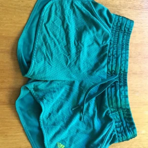  - Träningsshorts i petrolgrönt från Adidas. Supersköna och knappt använda (för trånga). Stretchig resår i midjan. 