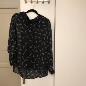 Transparent blus med revolvermotiv - * Extremt skön lätt transparent blus med pistol / revolver -motiv. Inköpt second hand i Barcelona, dock i princip nyskick. Ursprungligen kommer den från Mango. Underbar året runt! Storlek XL för den som i så fall vill ha en lite mer kroppsnära fit, sitter även fint på mig som är en M, och kan med säkerhet klä alla storlekar. 