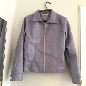 Lavendelfärgad skinnjacka  - Superfin fejk-skinnjacka i perfekt skick! Köpte den secondhand. Säljer den då den är för liten för mig. 
