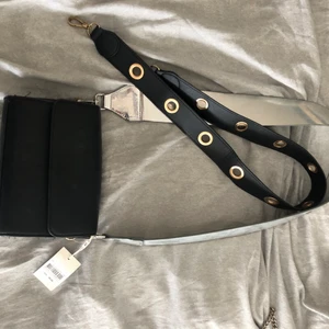 Väska - Hejsan, en simpel svart väska men två snygga band till, säljer jag. Jag köpte den på Lindex för 100kr och det silveriga bandet för 100kr. Därmed säljer jag den för 60kr. ✨✨ frakten står ni för💞