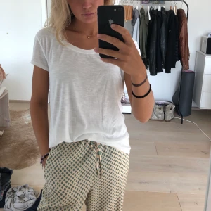 Längre T-shirt - Vit T-shirt i mjukt material som är lite längre i modellen. Väldigt skön. Aldrig använd.