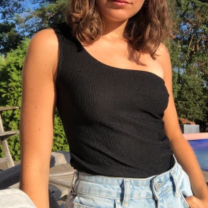 Svart One shoulder body - En svart ribbad body, one shoulder från hm i storlek s. 