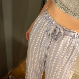 Byxor i pyjamasmodell  - Ett par mjukisbyxor från NAKD av Andrea hedenstedt. Använda ett par fåtal gånger. Sköna, luftiga i modellen. Ljusblå och vita ränder. Storlek 38. 