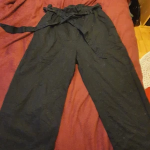 Paperbag byxor strl 42 - Svarta paperbagbyxor från H&M, justerbara i midjan!💥🖤säljes pga bara använt 2 gånger💣