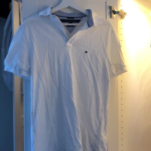 Vit pikétröja från Tommy Hilfiger  - Storlek M. Köpte den för ett år sen för att ha som strandtröja och det passade bra för mig. Den är i lite tjockare material än vanligt t-shirt material. Hör av dig om du vill ha bilder på eller mer info! Vid köp av flera saker blir det paketpris🌟