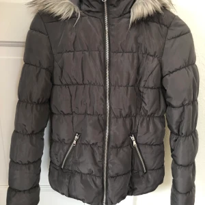 Grå jacka stl 34 - Mörkgrå vinterjacka i rak modell. Midjekort. Stl 34 men Passar även till stl 36