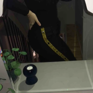 - Svarta ”low waist” kostymbyxor med gula detaljer längs benen. Aldrig använda, köpta på NA-KD i storlek 42.