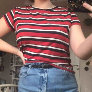  - Röd t-shirt med vita och marinblå/svarta ränder. Hyfsat använd och köpt på lager 157 i storlek M/L.