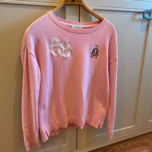  - En ljusrosa stickad Morris tröja. Väldigt stilren modell dock en liten fläck på tröjan därav priset 