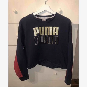  - En mörkblå magtröja med några röda inslag på armarna från puma, använd 1 gång. 