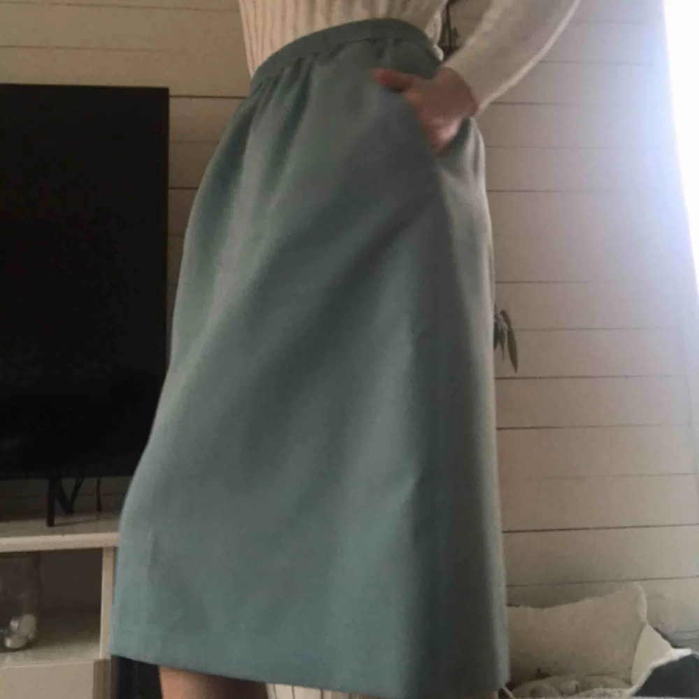 Fin och unik turkos kjol i tjockt material med fickor (!!!!). Tror den är handgjord av privatperson, därav ingen exakt storlek eller märke. Köpte den oanvänd secondhand. Använd 1 gång. Slutar strax under knät på mig som är 170 cm. Frakt tillkommer🧸. Kjolar.