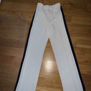  - Vita kostymbyxor med svart, blå och gul/orange revär från Zara. Storlek S. 