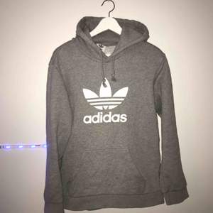 Grå Adidas hoodie till salu! Köpt på Zalando för 549kr och är använd 3-4 gånger, mycket bra skick. Frakten ingår i priset