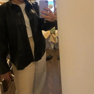 Skjorta i skinn  - Stilren skjorta i skinn från HM, har tillhörande skinnbyxor om intresse finns. Köpt för 500 kr, säljer för 200 kr exklusive frakt. 